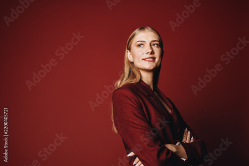 Young aspiring entrepreneur posing in red suit with confident expression