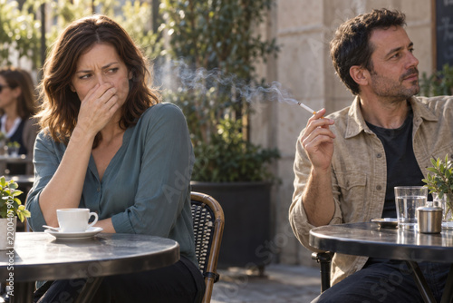 Woman Covering Her Nose as Cigarette Smoke Drifts from a Nearby Smoker at an Outdoor Cafe