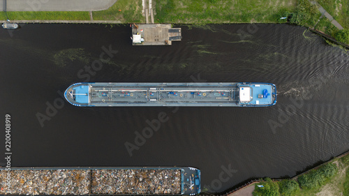 Aerial top-down view of a cargo barge navigating a canal