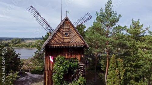 Majestic wooden windmill standing among pine trees near a river in kazimierz dolny, poland. Rural landscape showcasing traditional architecture. Kazimierz dolny, poland