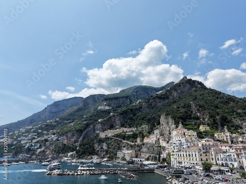 aerial view of Amalfi Harbour and beach front pleasure boats and yacht parked in the blue water of the Tyrrhenian Sea part of the larger Mediterranean Sea