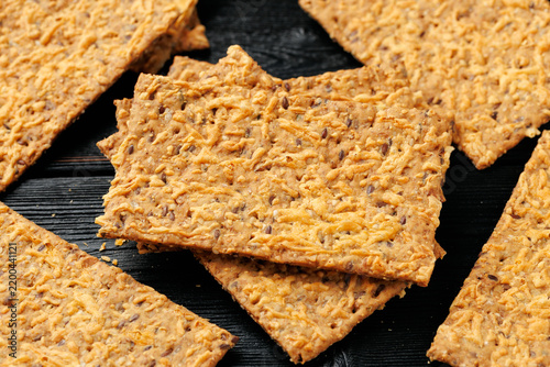 Bild auf Leinwand Wholegrain Cheese Crispbread with Mixed Seeds on Dark Background