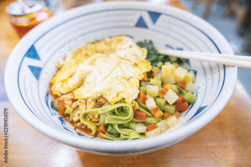 Canvastavla A steaming bowl of Chinese-style cold noodles with egg, vegetables, and sauce —