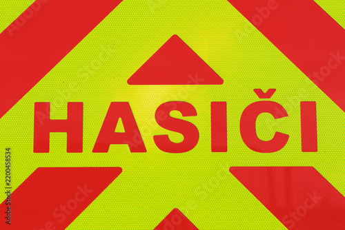 Hasici (translation from Czech: firemen). Detail of a red fire truck with reflective lettering. Public emergency services provided by firefighters and rescuers in the Czech Republic.