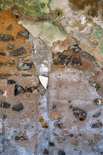 Old weathered stone and concrete wall texture with cracks, peeling plaster and industrial grunge surface
