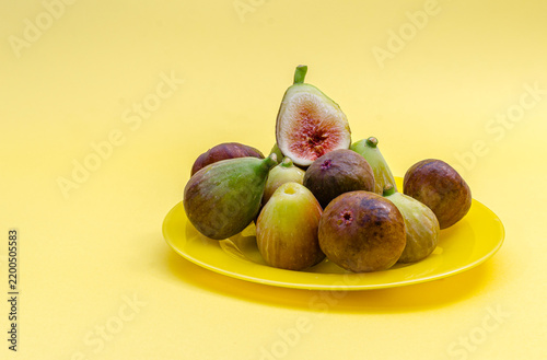 Fresh Ripe Figs on Yellow Plate Isolated on Yellow Background