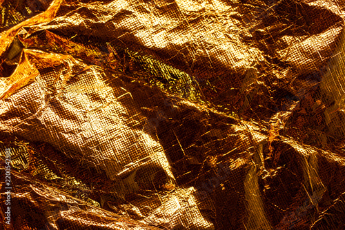 Close-up of a vibrant golden crumpled metallic foil with a textured surface.