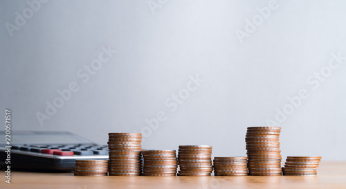 Coins stacks and calculator on wooden table for financial planning and accounting concept   