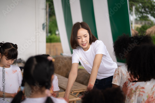 A dedicated educator passionately engages with a group of children, fostering creativity and learning in a dynamic, interactive environment.
