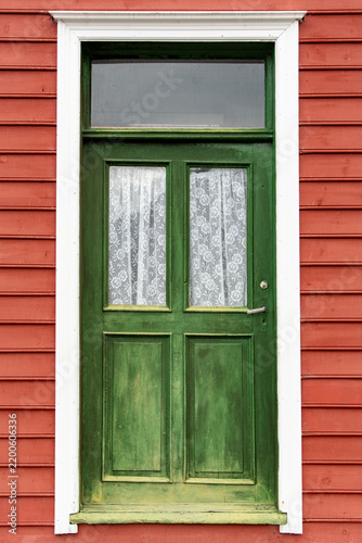 Green door on red wooden wall detail