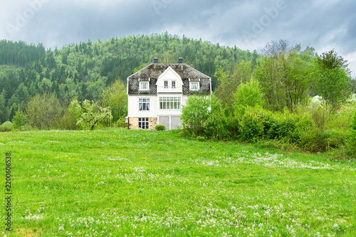 White house in green meadow Norway countryside