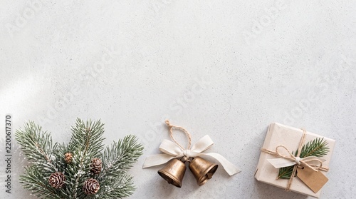 Winter table setting features golden bells evergreen branches and a wrapped gift