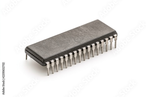 Microcontroller chip with metallic pins against white background.