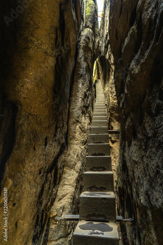 Himmelsleiter staircase leading through narrow rock crevice at Kuhstall in Saxon Switzerland National Park, Germany, popular destination for hiking and nature exploration.