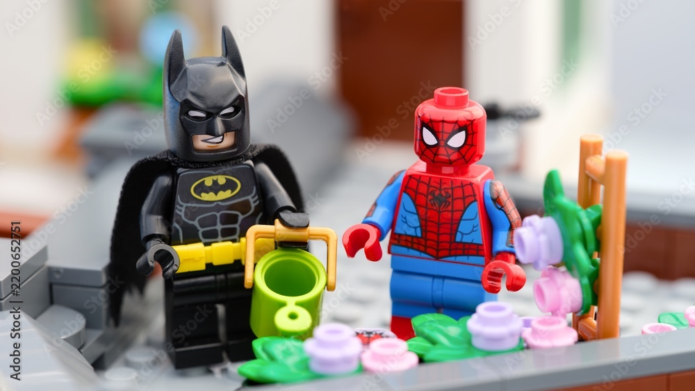 Fototapeta premium Tambov, Russian Federation - August 23, 2026 Lego Batman and Spider-Man minifigures gardening together on a rooftop terrace.