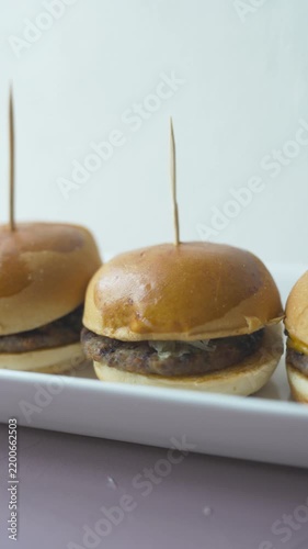 mini burgers or sliders served on a stylish wooden board