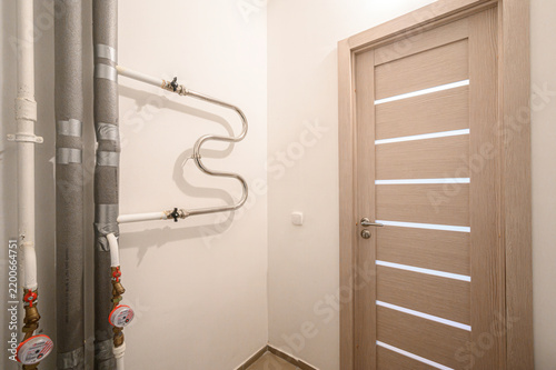 Fotografía Utility corner features exposed plumbing pipes, water meters, brass valves, S‑sh