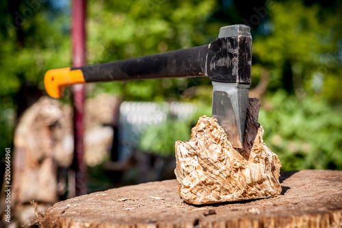 Obraz na plátne Axe embedded in wood chopping block outdoors