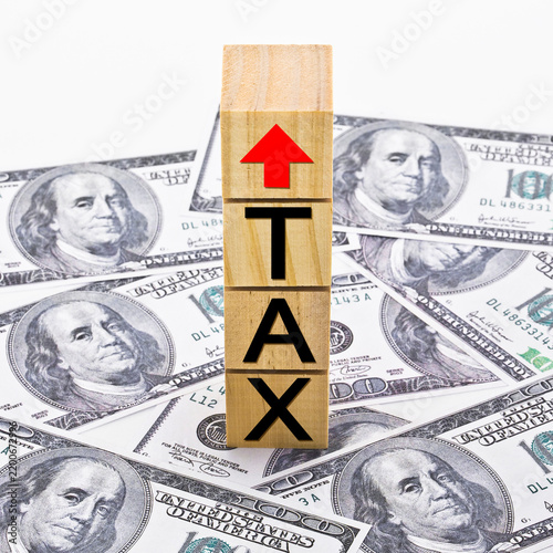 TAX GROWTH CONCEPT with text and arrow written on wooden cubes and US Paper