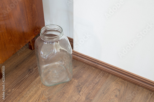 Foto Big transparent glass container used as a decorative or storage element on a hardwood surface