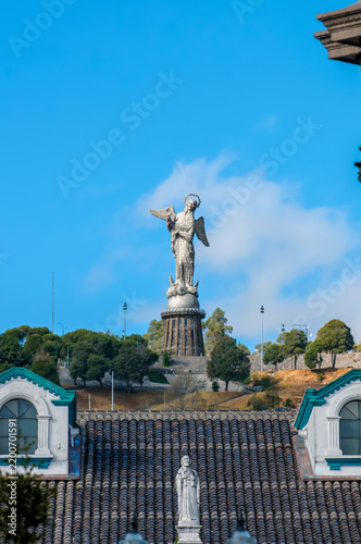 Majestic Virgin of El Panecillo in Quito, Ecuador, under a blue sky