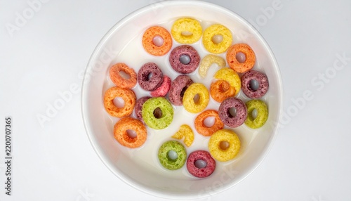 Colorful Fruit Flavored Cereal Loops in White Bowl with Milk Overhead View