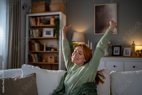 Canvastavla Woman stretching arms enjoying morning comfort on couch