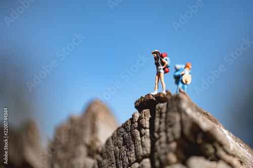 Backpackers reaching mountain top under blue sky