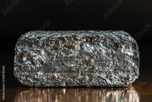 Compressed block of aluminum scrap formed from processed non ferrous metal waste, irregular structure of compacted aluminum fragments. Secondary raw material for metallurgical and metal processing ind