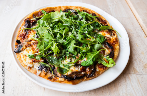 Tasty gluten free pizza with wild mushrooms and arugula from a popular restaurant and wine bar.