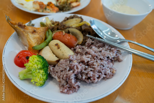 Фотография Korean hotel breakfast buffet plate served with multigrain purple rice, beef bulgogi, grilled salmon and fresh vegetables