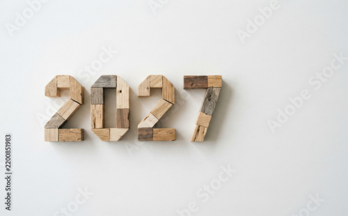 Wooden numbers 2027 made of recycled wood blocks on a white background representing the future year and new beginning