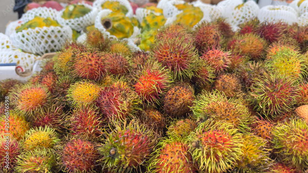 Fototapeta premium Rambutan tropical fruit at market stall displaying vibrant colors