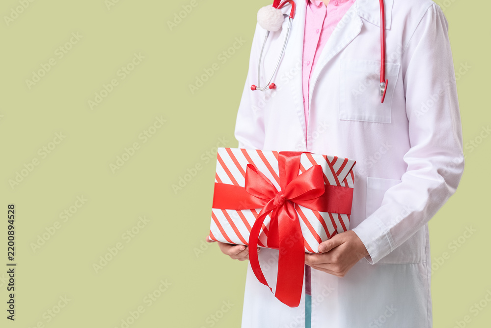 Obraz premium Healthcare appreciation and medical staff bonus, doctor holding a gift box with red ribbon for holiday celebration or patient gratitude in hospital