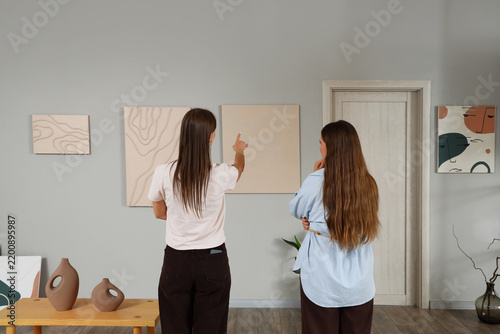 Fotografie Art appreciation and interior design, two women looking at abstract paintings in