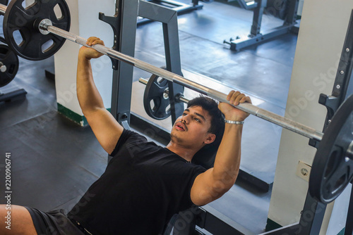 фотографія Focused Asian Male Athlete Lifting Heavy Barbell Weights