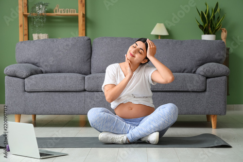 Beautiful pregnant woman doing yoga at home