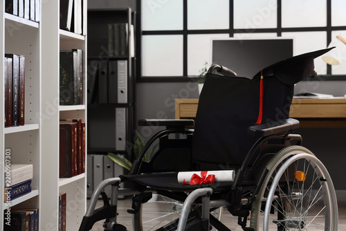Wheelchair with diploma and graduation hat in library