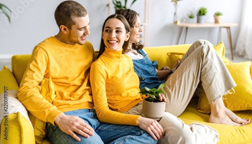 Young Friends Hanging Out Together on a Yellow Sofa with a Potted Plant