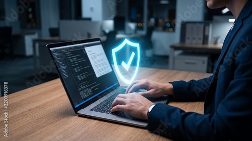 Professional businessman typing on laptop with glowing cybersecurity shield icon overlay
