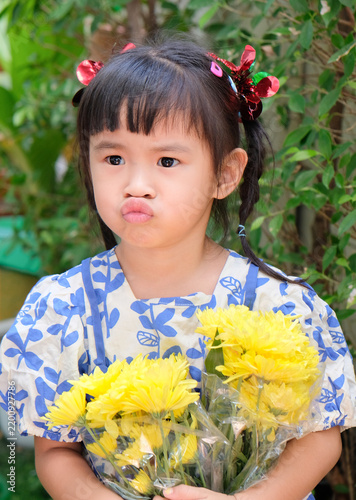 Young Asian Girl Holding Yellow Chrysanthemum Flowers Outdoors