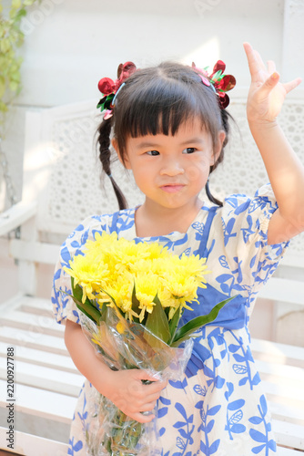 Young Asian Girl Holding Yellow Chrysanthemum Flowers Outdoors