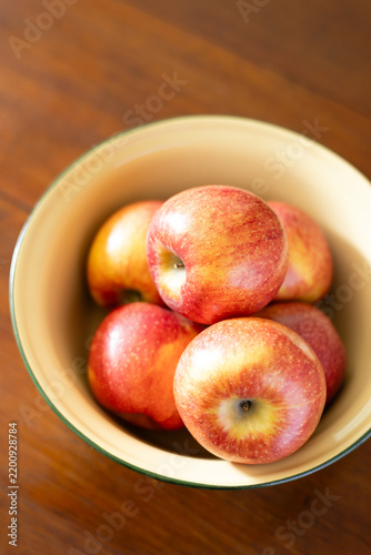 Close-up of red apples in a yellow bowl.