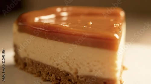 Close-up of Decadent Caramel Cheesecake Slice with Creamy Filling and Crumbly Biscuit Crust, Showing Rich Layered Texture in Appetizing Food Shot