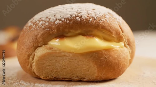 Golden baked pastry filled with rich custard cream and topped with white powdered sugar, perfect for a sweet dessert or snack.