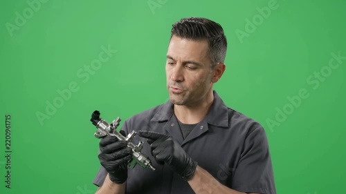 Mechanic Inspecting Metal Mechanical Part Against Green Screen