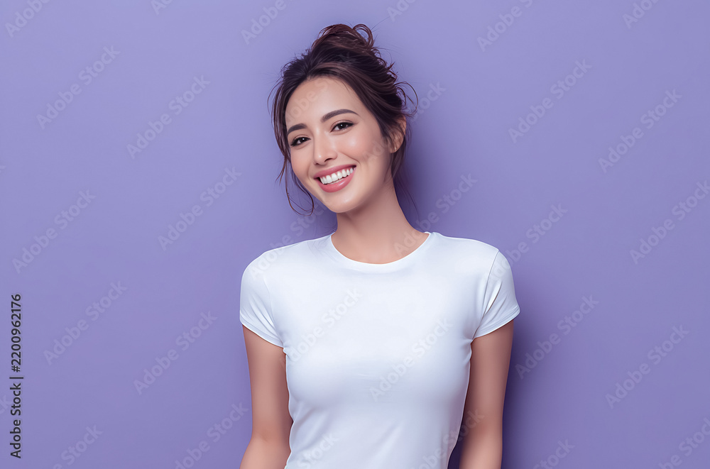 Obraz premium Young Asian woman in a white t shirt posing on a soft pastel background expressing comfort, simplicity, and relaxed home lifestyle.