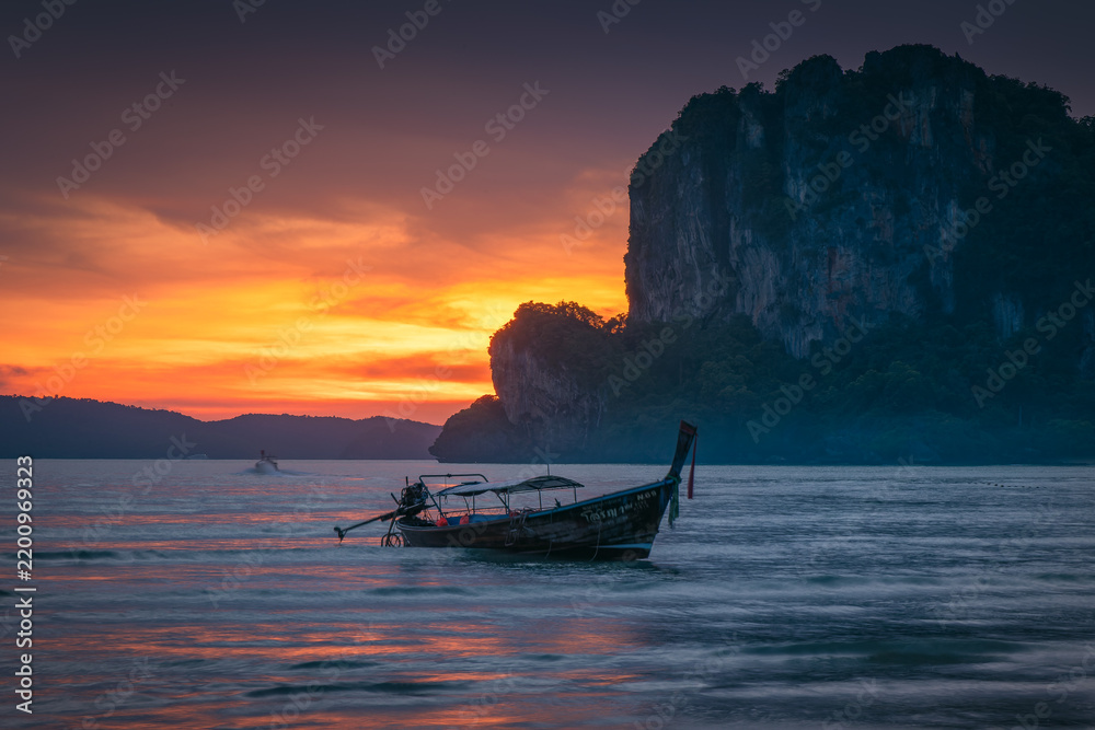 Obraz premium Natural scenery of long-tail boats at the seaside at sunset on Railay Beach, Krabi, Thailand