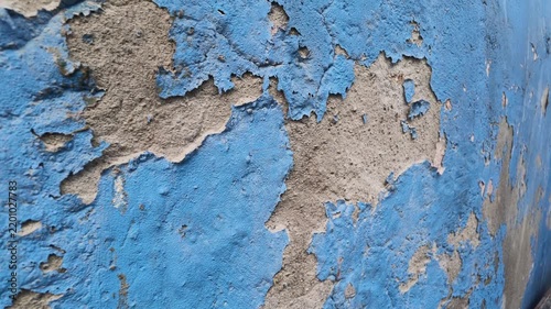 Old blue wall with peeling paint in a worn building