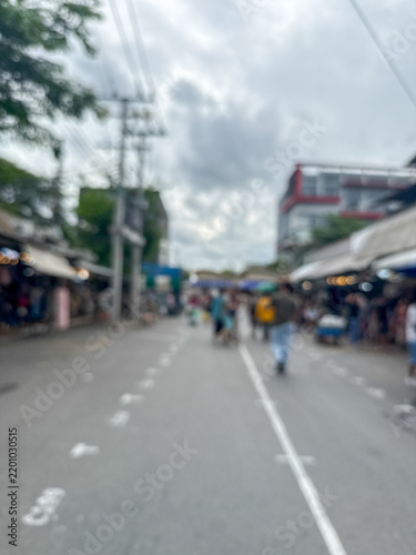 blurred view of people and a busy crowd walking down a street in an outdoor market